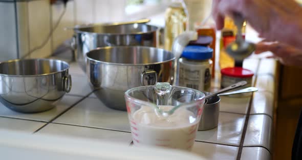 A chef pouring ingredients into a measuring cup while baking a vegan chocolate cake dessert recipe i