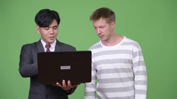 Young Handsome Asian Businessman and Young Scandinavian Businessman Working Together