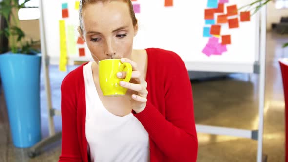 Executive having coffee while working in the office