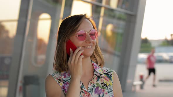 Girl Wearing Trendy Sunglasses Uses Her Phone. Using Smartphone for Call, Talk. Vacations, Tourism