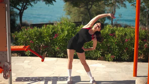 Wide Shot Joyful Young Sportswoman Bending in Slow Motion Smiling Looking at Camera