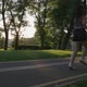 SLOW MOTION CLOSE UP Female Running in Green Park in Small Suburban Town with Tall Buildings in the - VideoHive Item for Sale