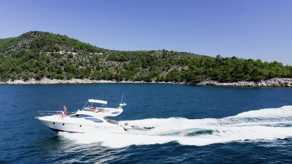 Luxury yacht with family sailing in the sea, drone view, summertime holidays.