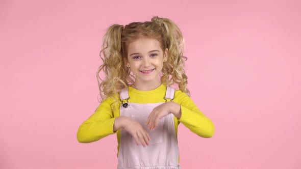 Pretty Little Girl Is Pointing To Something with Her Hands. Slow Motion