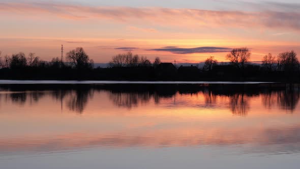 Red Sunset Over the Water of a Village Lake