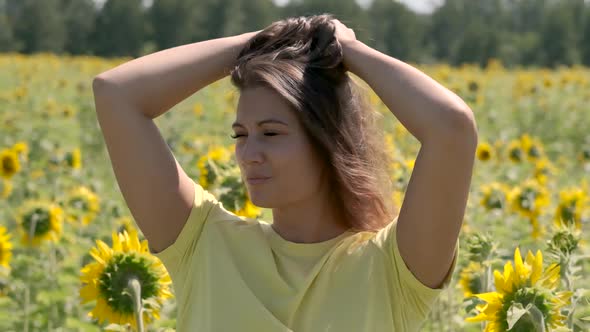 Beautiful Young Girl Posing Standing in a Field with Sunflowers