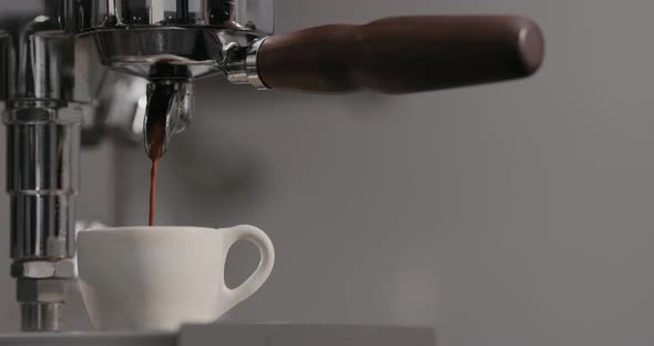 Slow Motion Man Making Espresso with Single Spout Portafilter on Coffee Machine