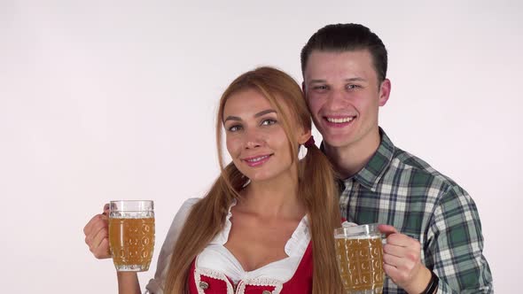 Beautiful Bavarian Couple Celebrating Oktoberfest, Drinking Beer Together