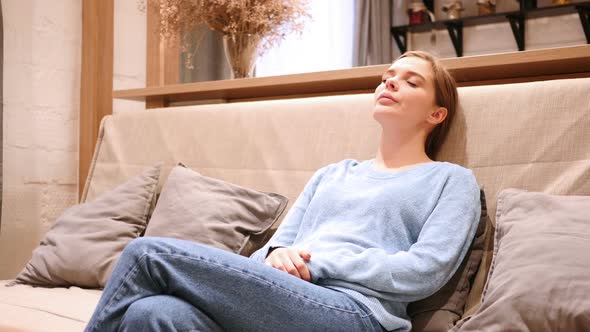 Sleeping Tired Young Woman on Sofa at Home