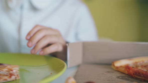 Schoolkid Sits Eating Delicious Pizza at Table Slow Motion