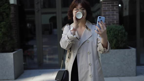 Woman with Brown Hair in Trench Coat Chatting By Video Chat