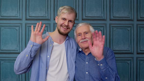 Happy Different Male Generations Family of Senior Father and Adult Son or Grandson Waving Hi Hello