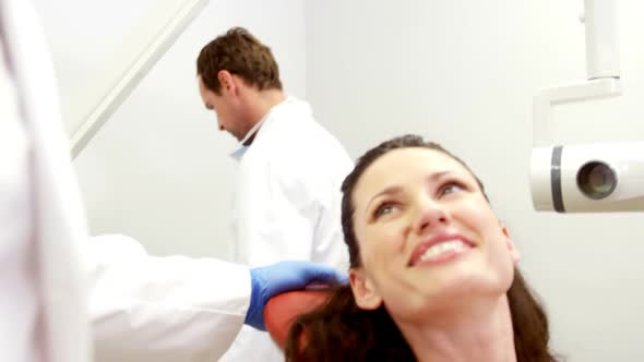 Smiling dentist and patient interacting with each other