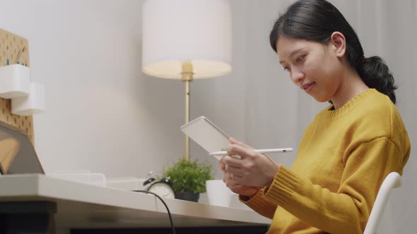 Asian woman using a tablet write an article.