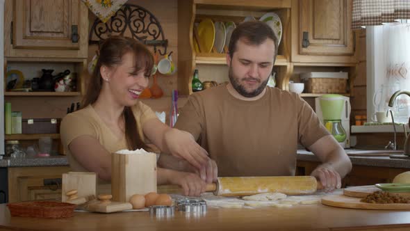 The Husband Rolls a Yeast-free Dough for Making Cookies.