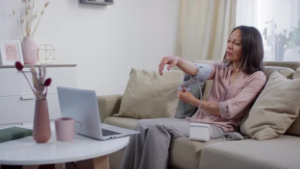 Woman Using Blood Pressure Monitor