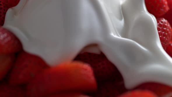 Pouring milk on strawberries. Slow Motion.