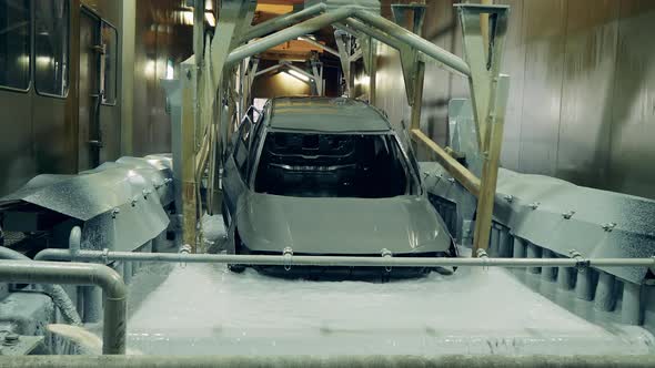 Car Being Dipped in a Chemical Solution at a Car Factory