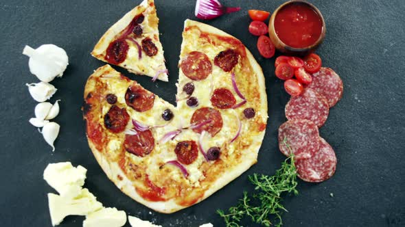 Italian pizza on wooden table with vegetables and spices