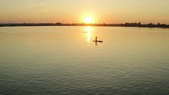 A Woman is Sitting on a Board and Rowing