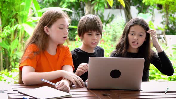 Children, boy and girl, using laptop computer for online learning in garden at home