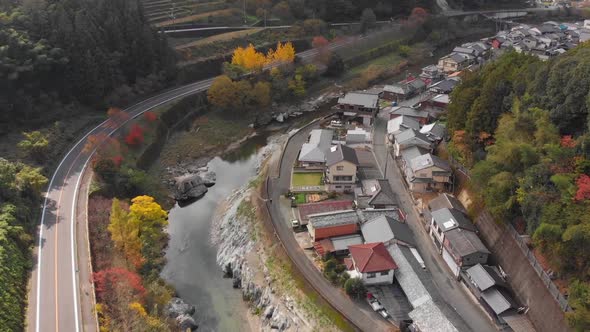 small village in the mountains with a river running through in autumn