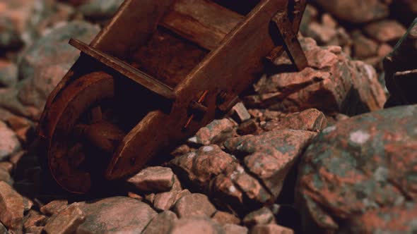 Abandoned Wooden Mine Wheelbarrow on Rocks