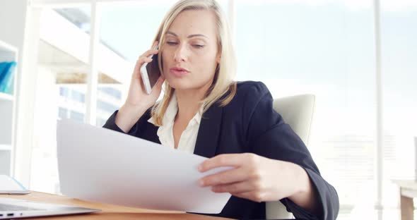 Businesswoman talking on the mobile phone at her desk