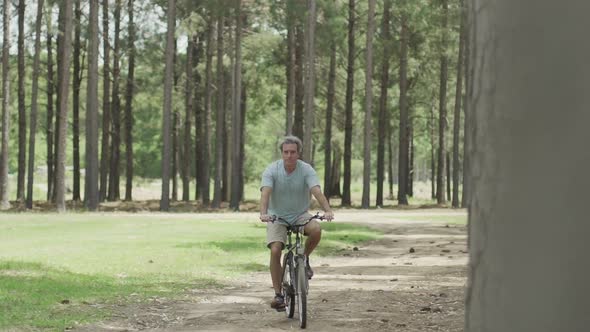 Mature man riding bicycle in park