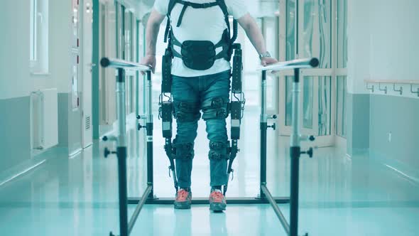Male Patient in the Exosuit is Walking Along the Hospital By Himself