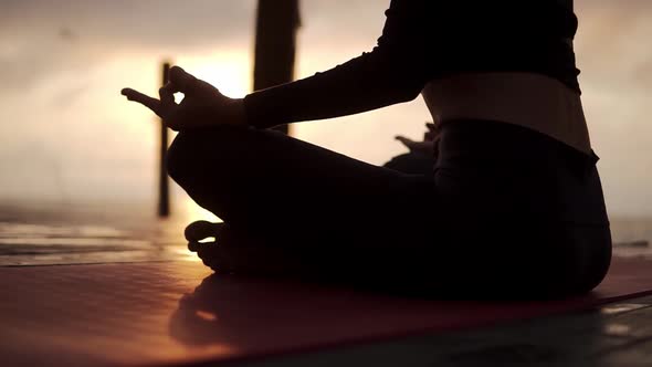 Silhouette of Unrecognizable Yogi Girl Sitting in Lotus Pose in Front the Sea Meditating Sunshining