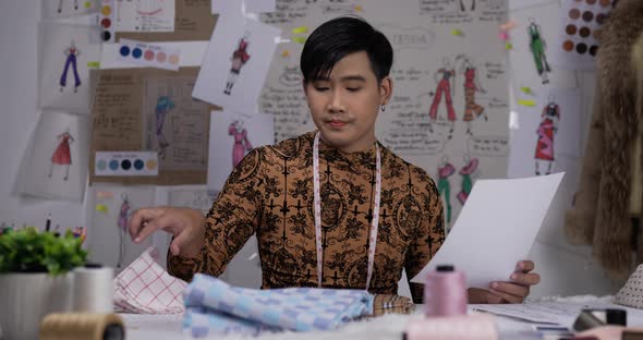 Portrait of fashion designer man checking the quality and design