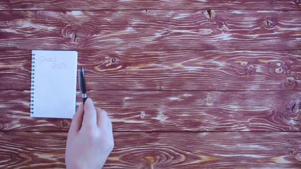 Male Hands Put a Cup of Coffee a Spoon a Pen Notepad and Smartphone on a Wooden Vintage Table