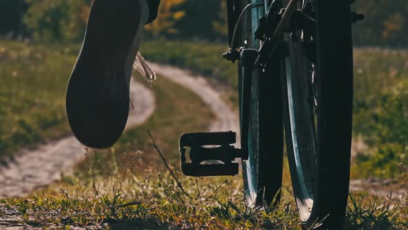 Young Woman on Bicycle Rides Along Green Forest Path in Summer Day Slow Motion