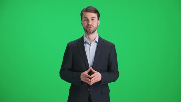 Man Reporter in Suit Looks Into the Camera and Speaks Stands on a Green Background a Template for TV