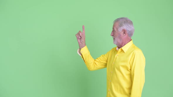 Happy Senior Bearded Businessman Talking While Pointing Up