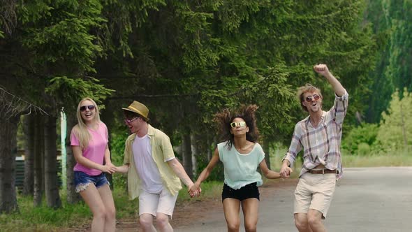 Happy Young Women and Men Jumping, Dancing to Music at Outdoor Party, Youth