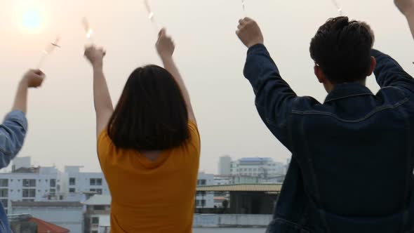 Group of Asian young people clinking bottles of beer party on the rooftop.