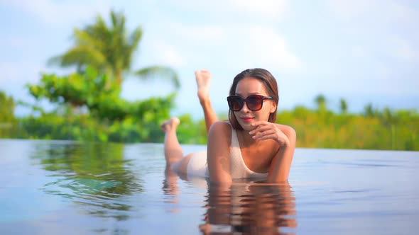 Young asian woman enjoy around outdoor swimming pool for leisure