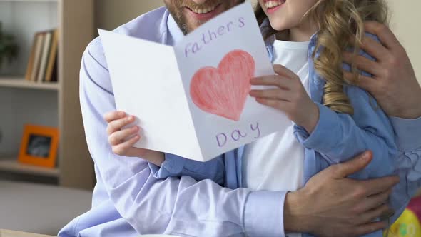 Happy Man Hugging Daughter Holding Handmade Fathers Day Card, Tender Relations