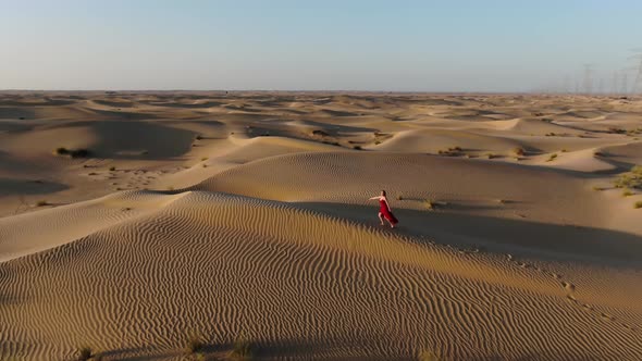 Sunset Walk in the Desert By a Young Woman in Long Red Dress