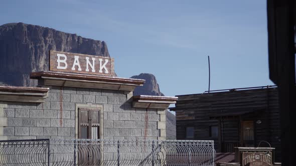 Old west town bank sign and mountains in background