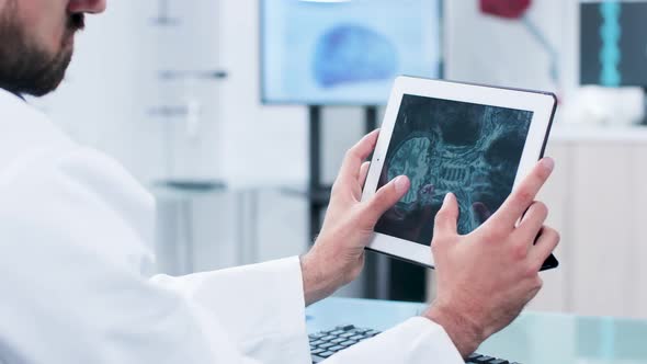 Doctor Looking and Analyzing a X Ray on a Digital Tablet Pc Screen