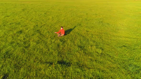 Low Altitude Radial Flight Over Sport Yoga Man at Perfect Green Grass. Sunset in Mountain.