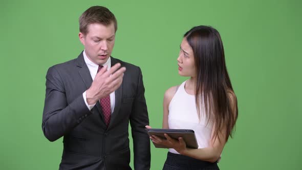 Young Asian Businesswoman Showing Bad News To Young Businessman