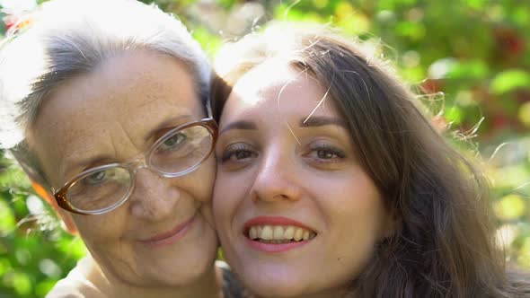 Happy Senior Mother in Eyeglasses is Hugging Her Adult Daughter the Women are Enjoying Together