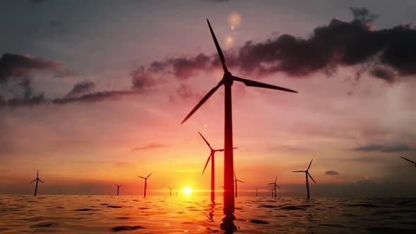 Wind Turbines Silhouettes Spinning In An Offshore Wind Farm In The Ocean Against The Sunset