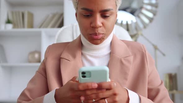 Focused Tense African American Business Woman Typing SMS Messages in Phone