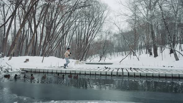 Jogger Crossing Bridge Over River in Winter Park