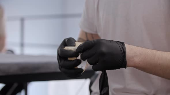 Young Man Wrapping the Tattoo Machine Over with Duct Tape